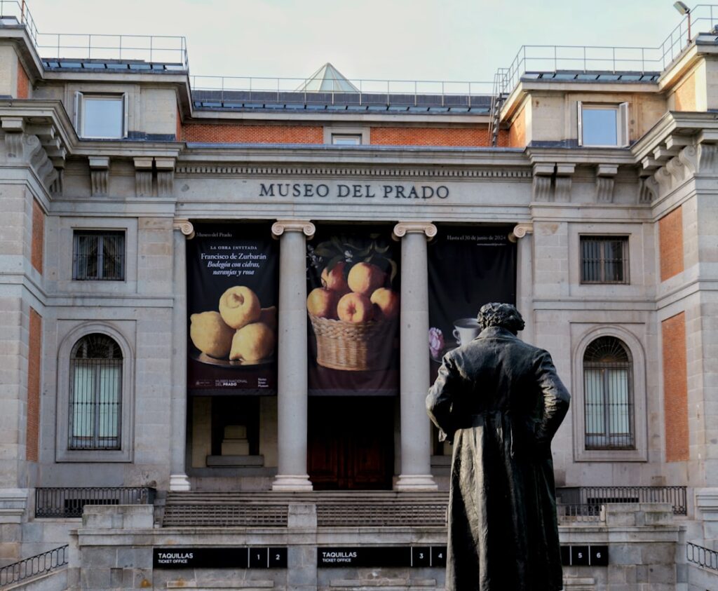 The museo del prado building with a statue in front.