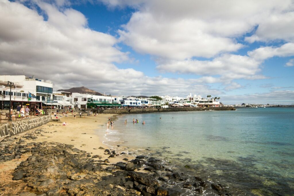 White buildings line a sandy beach with clear blue water